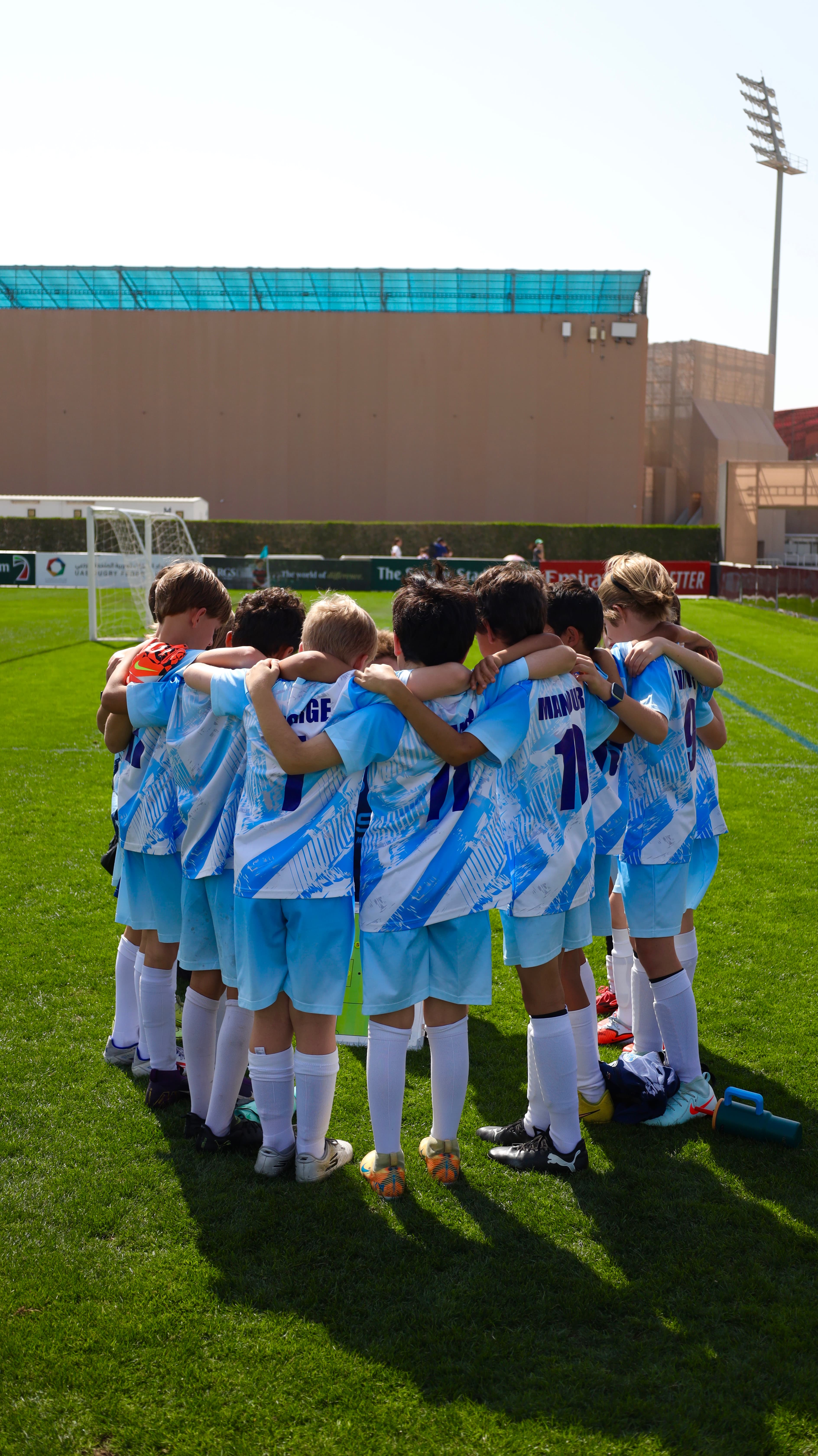 NXTGEN Squad players gather in a matchday huddle.
